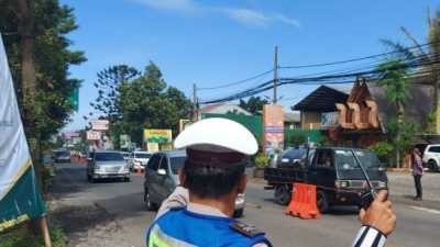 Petugas tengah mengatur arus lalu lintas
