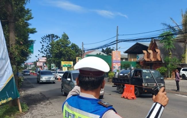 Petugas tengah mengatur arus lalu lintas